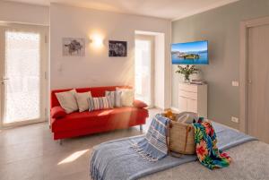 a living room with a red couch and a table at Casa Quadrifoglio - Valgrande in Intra