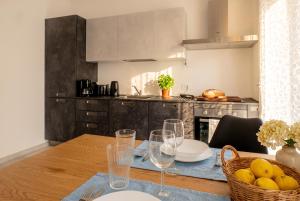 a kitchen with a wooden table with wine glasses at Casa Quadrifoglio - Valgrande in Intra