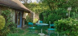 a table and chairs in front of a house at Une chambre en Amazonie in Le Menoux