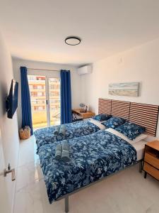 a bedroom with a bed with blue sheets and a window at Punta Prima Sun & Sea Apartament in Punta Prima +6 photos