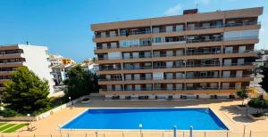 a building with a swimming pool in front of a building at Punta Prima Sun & Sea Apartament in Punta Prima
