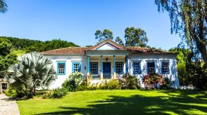 uma casa azul e branca com um quintal em Hotel Fazenda Florença em Conservatória