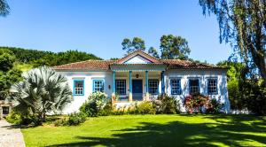 a blue and white house with a yard at Hotel Fazenda Florença in Conservatória