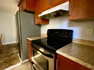 a kitchen with a black stove and a refrigerator at Aldergrove 2 in St. John's
