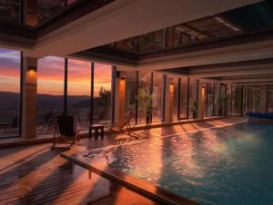 a large swimming pool in a house with a sunset at Apartman BIG Milmari S19 in Kopaonik