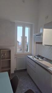 a white kitchen with a stove and a window at Mansio Pegaso in Tivoli +6 photos
