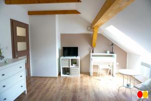 a attic room with a table and a desk in a room at Rovenská Chalupa in Strážov
