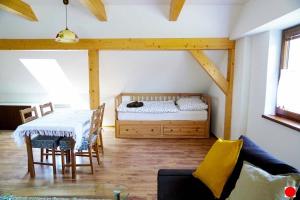 a room with a bed and a table and chairs at Rovenská Chalupa in Strážov
