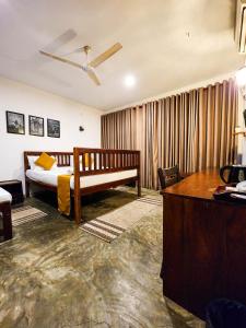 a bedroom with a bed and a desk in a room at New Moonstone Tangalle in Tangalle