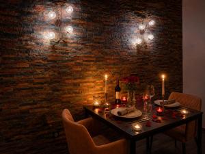 a dining room table with candles and a brick wall at Suite avec Jacuzzi - Clim - Terrasse - Wi-Fi in Agde