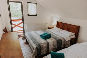 a bedroom with two beds and a green pillow on the bed at Hanul Morii in Ciucea +64 photos