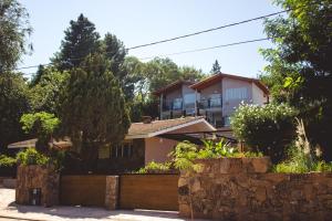 a house with a stone fence in front of it at Grateus Apart in Villa General Belgrano