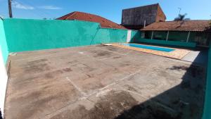 a patio with a blue wall and a swimming pool at Edícula Gigá in Brotas
