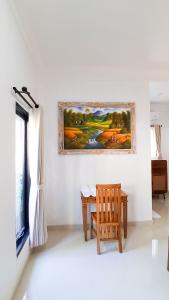a room with a table and a painting on the wall at Rumah Merta Sari in Bingin Beach
