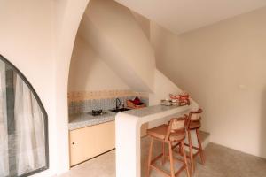 an attic kitchen with a counter and two stools at Maroko Jogja Villas With Privatepool in Ngaglik