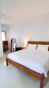 a bedroom with a large white bed in a room at Rumah Merta Sari in Bingin Beach