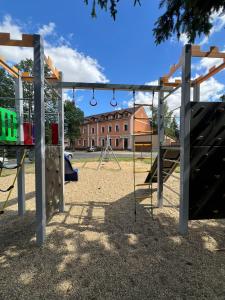 ein leerer Spielplatz mit Schaukeln und einem Gebäude in der Unterkunft Amálka u Řípu in Straškov