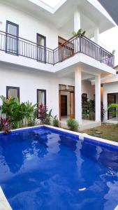 a house with a large blue pool in front of it at Rumah Merta Sari in Bingin Beach