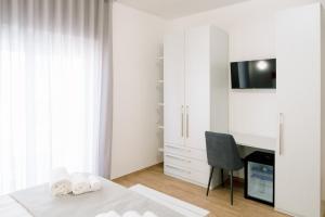 a bedroom with a desk and a bed with towels at B&B Da Anna in Torretta