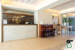a living room with a piano and a table at Hotiday Corfu Kanoni in Corfu