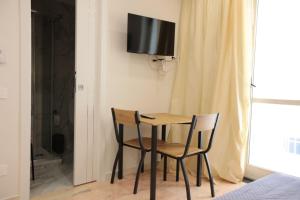 a small table with two chairs and a television on a wall at Dimora del mare in Agropoli