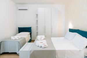 a room with two beds and a table with towels at B&B Da Anna in Torretta
