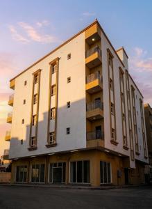 a tall building with a sunset in the background at RED Bn Saif in Salalah