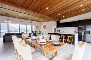 a kitchen and dining room with a wooden table and chairs at Grand Peninsula Lodge in Wanaka