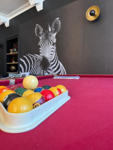 a table with a bowl of fruit in front of a zebra at Balcony by Giorgi - Centre de Bastogne in Bastogne