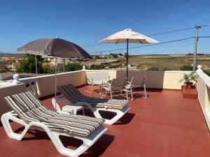 a patio with chairs and umbrellas on a roof at The Courtyard Studio Apartments in Fuente Alamo