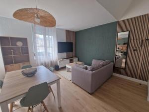 a living room with a table and a couch at Casa Bahia in Berck-sur-Mer