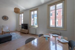 a living room with a table and chairs and windows at Le Reflet de L'eau - Plages à proximité in Eu