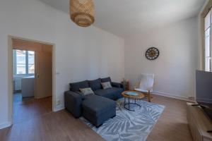 a living room with a blue couch and a table at Le Reflet de L'eau - Plages à proximité in Eu