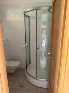a woman standing in a shower in a bathroom at Jacht Apartmanok in Balatonfüred +26 photos