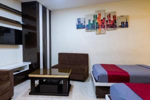 a bedroom with a bed and a table and a tv at Abis Inn -Ballygunge in Kolkata