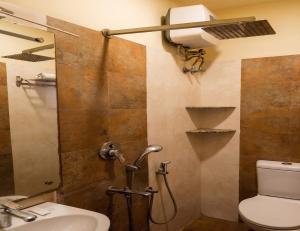 a bathroom with a shower with a toilet and a sink at Abis Inn -Ballygunge in Kolkata