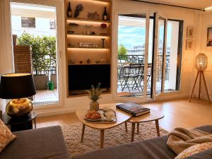 a living room with a television and a table with fruit on it at Le Penthouse de Levallois in Levallois-Perret