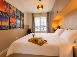 a white bed with a tray of food on it at Le Penthouse de Levallois in Levallois-Perret