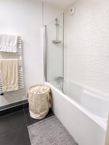 a white bathroom with a tub and a shower at Le Penthouse de Levallois in Levallois-Perret +15 photos