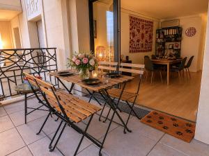a table and chairs with a vase of flowers on it at Le Penthouse de Levallois in Levallois-Perret