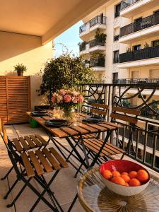 a table and chairs on a balcony with a bowl of oranges at Le Penthouse de Levallois in Levallois-Perret