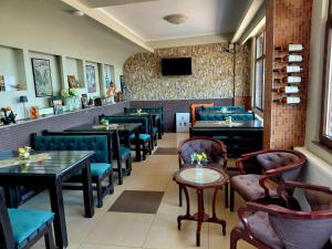 a restaurant with tables and chairs and a flat screen tv at DENY INN Funland in Zărneşti