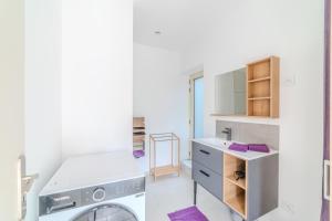 a bathroom with a washing machine and a sink at La Demeure des Sources - Iris - Avec climatisation in Bourbon-Lancy