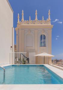 a house with a swimming pool in front of a building at Líbere Alicante Rambla in Alicante