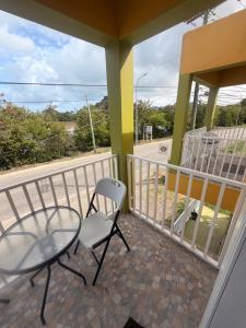 a balcony with a glass table and a chair at Sunfusion apartment & Cottages in Saint Mary