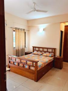a bedroom with a wooden bed in a room at Siolim Serenity in Siolim