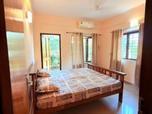 a bedroom with a bed in a room with windows at Siolim Serenity in Siolim