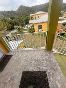 a balcony with a view of a house at Sunfusion apartment & Cottages in Saint Mary