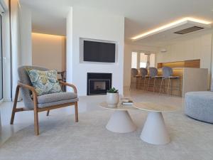 a living room with a chair and a table at Beachfront 3bdr apt on Marginal Boulevard in São Martinho do Porto