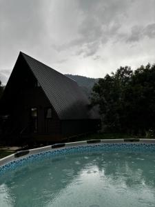 a house with a swimming pool in front of a building at kesis chalet in Borjomi